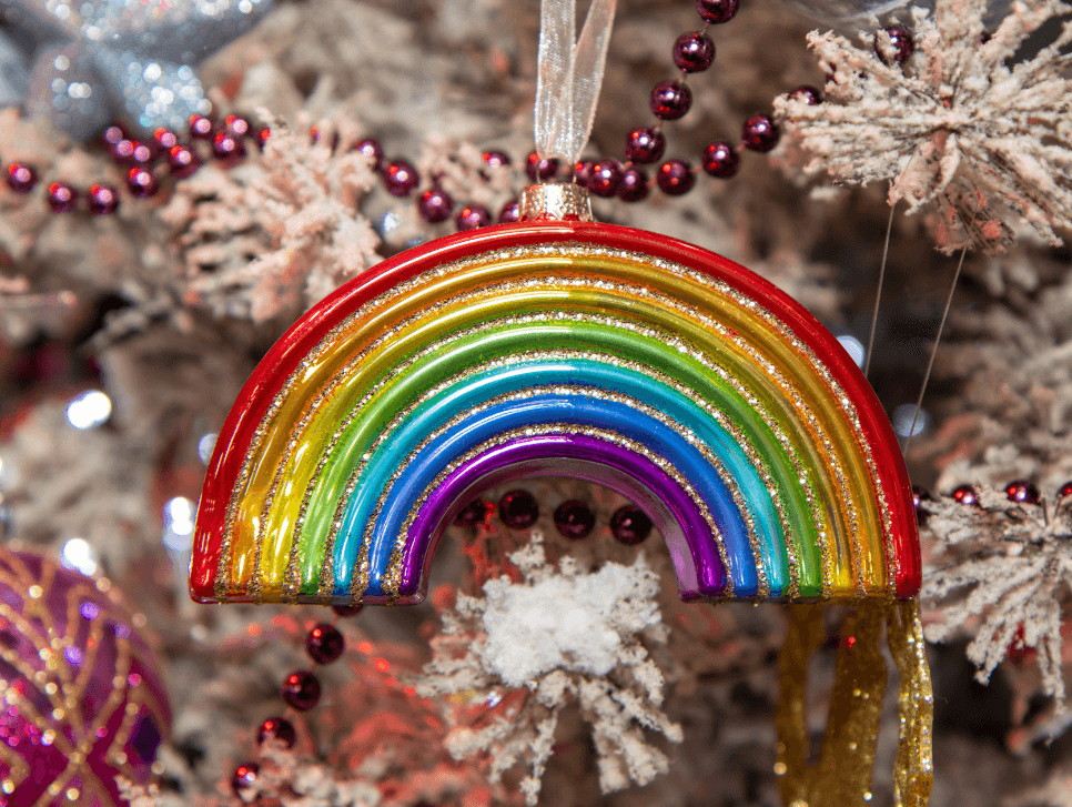 Pride ornament hanging on a Christmas tree.