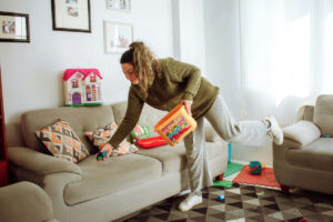 A woman cleaning toys in the living room