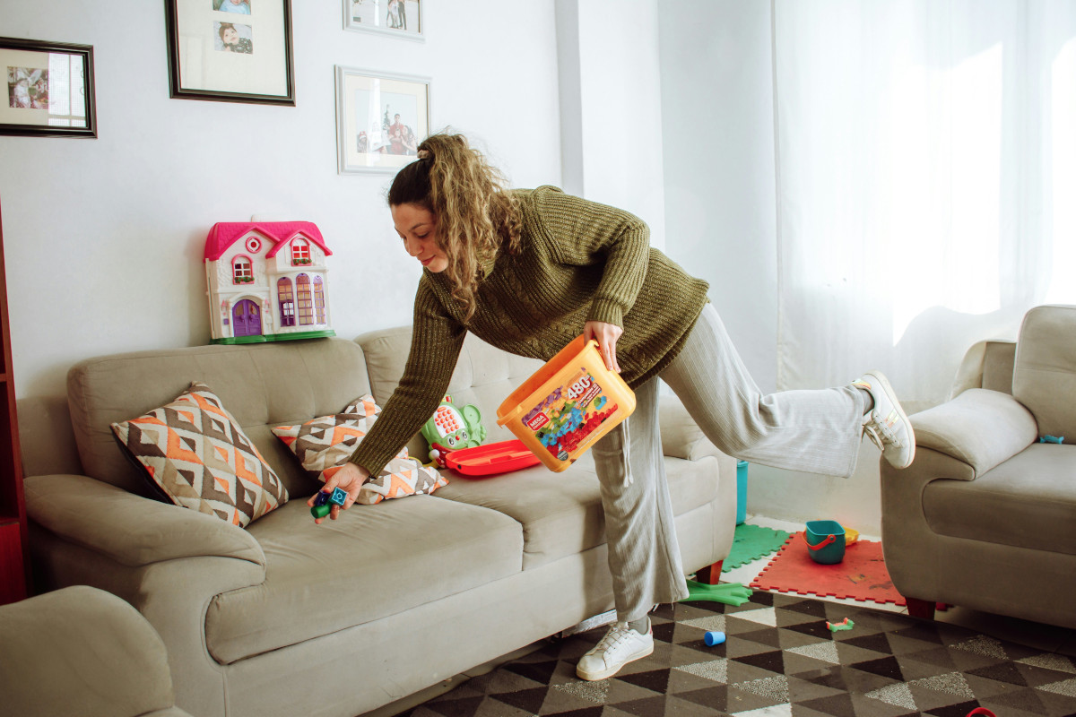 A woman cleaning toys in the living room
